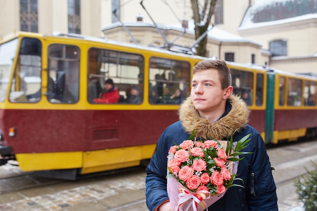 Widok z tyłu młodego mężczyzny trzymającego czerwoną różę