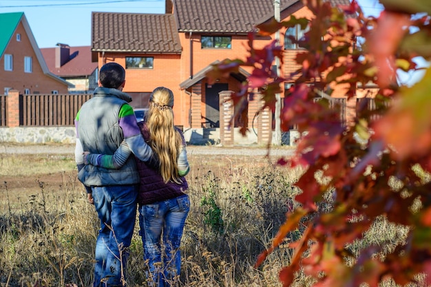 Zdjęcie widok z tyłu młodej pary patrzącej na swój nowy dom