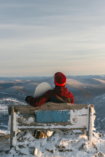 Widok Z Tyłu Na Snowboardzistę Na ławce Na Szczycie Ośrodka Narciarskiego