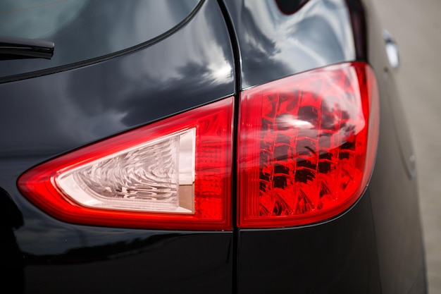 Widok z tyłu nowego czarnego samochodu Zbliżenie reflektory samochodu Czarny crossover miejski premium luksusowy SUV zbliżenie tylne światło Zbliżenie lampy samochodowej