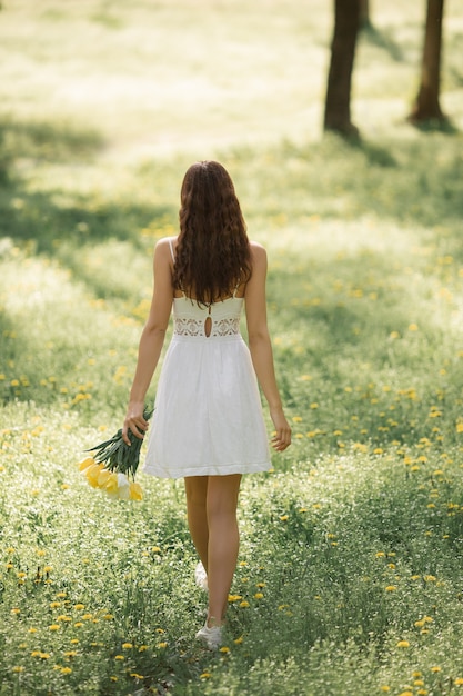 Widok Z Tyłu Og Atrakcyjna Kobieta W Białej Sukni Z Bukietem Wiosennych Kwiatów Idących Przeciwko