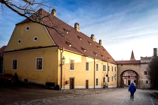 Widok z tyłu osoby idącej w kierunku budynku