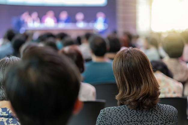 Widok z tyłu publiczności w sali konferencyjnej lub na spotkaniu seminaryjnym z udziałem głośników