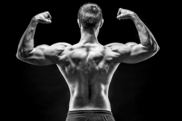 Widok z tyłu umięśnionego młodego mężczyzny pokazującego plecy, mięśnie bicepsa