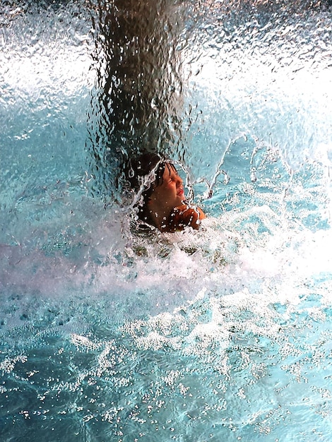 Zdjęcie widok z wysokiego kąta chłopca pływającego w basenie
