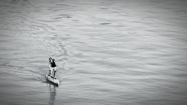 Zdjęcie widok z wysokiego kąta człowieka jeżdżącego na paddleboardzie w morzu