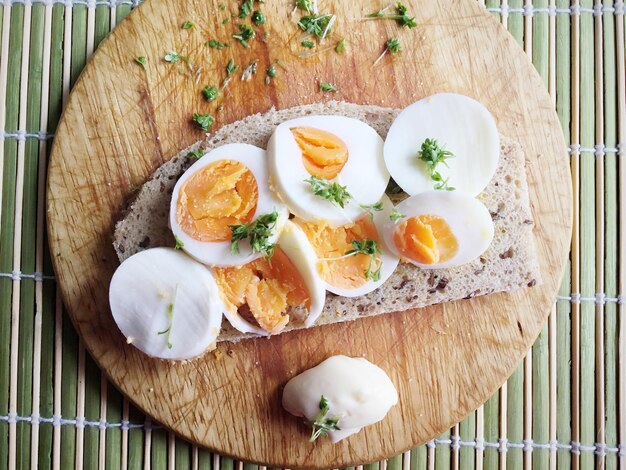 Zdjęcie widok z wysokiego kąta na gotowane jajka i chleb na drewnianej talerzu
