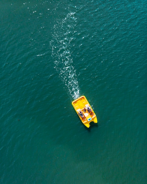 Zdjęcie widok z wysokiego kąta na ludzi pływających łodzią na morzu
