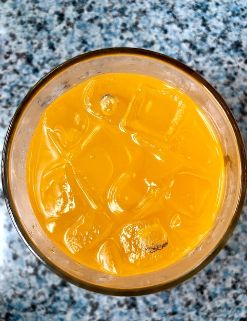 Zdjęcie widok z wysokiego kąta na napój pomarańczowy z kostkami lodu