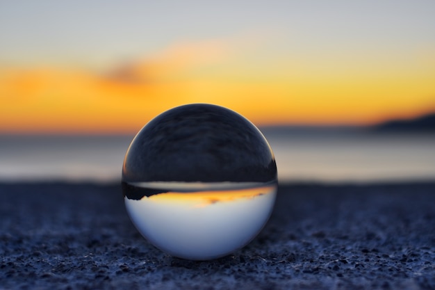 widok zachodu słońca przez kulę fotograficzną Lensball