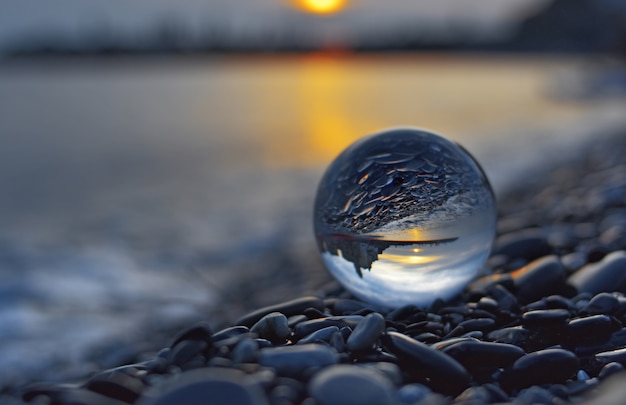 widok zachodu słońca przez kulę fotograficzną Lensball