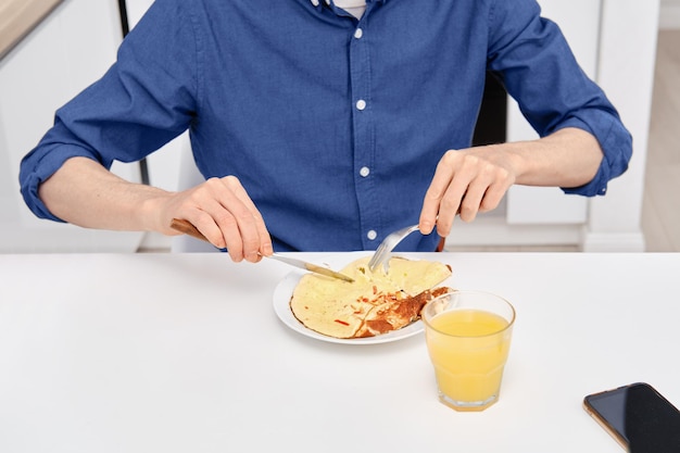 Widok zbliżenie człowieka jedzącego omlet