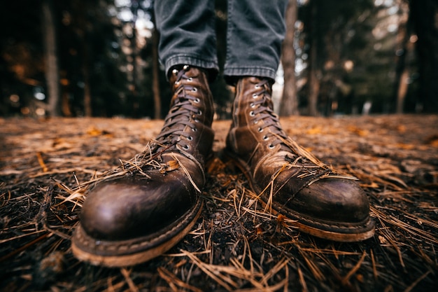 widok zbliżenie na męskie nogi w vintage skórzane buty w parku jesień