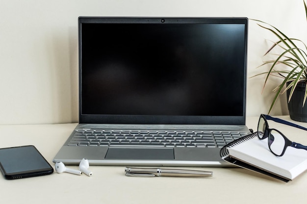 Widok zbliżenie otwartego pustego ekranu laptopa z materiałami biurowymi w nowoczesnym biurze