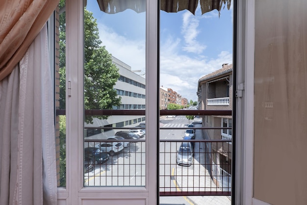 Widoki na ulicę z okna z białymi aluminiowymi i szklanymi drzwiami składanymi