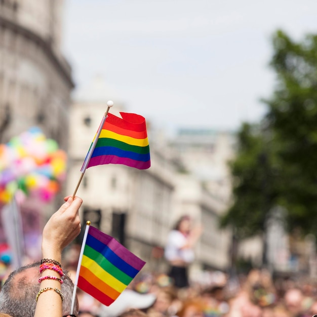 Widz macha tęczową flagą gejów podczas marszu dumy gejów LGBT w Londynie