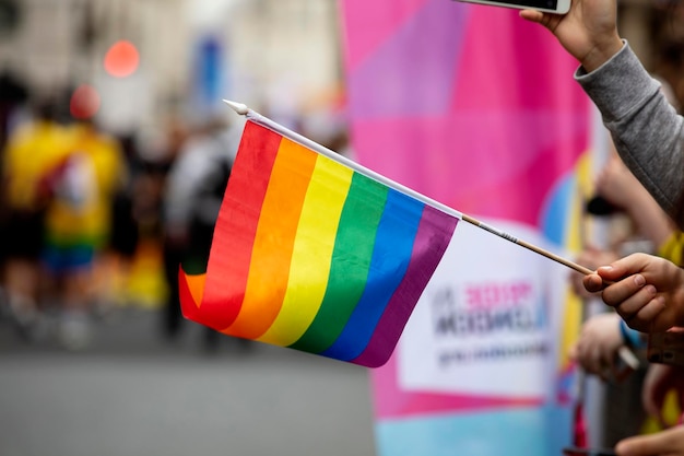 Widzowie machają gejowską tęczową flagą na imprezie społeczności LGBT Gay Pride