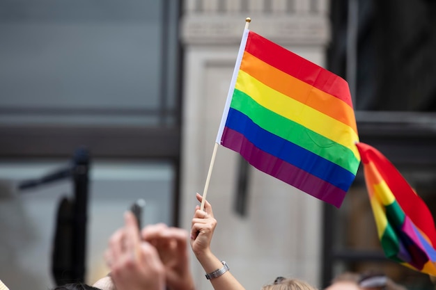 Widzowie machają gejowską tęczową flagą na imprezie społeczności LGBT Gay Pride