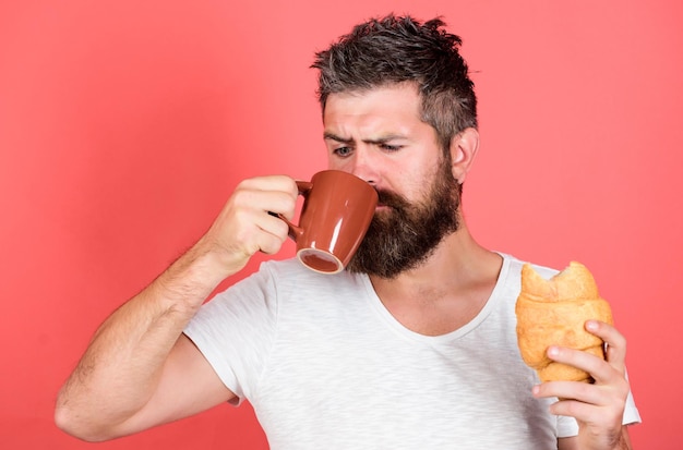 Więcej kawy Koncepcja porannej tradycji Świeżo upieczony croissant Pyszne śniadanie Niezdrowe, ale pyszne śniadanie Idealne dopasowanie Poczuj głód Brodaty hipster delektuj się śniadaniem pij kawę