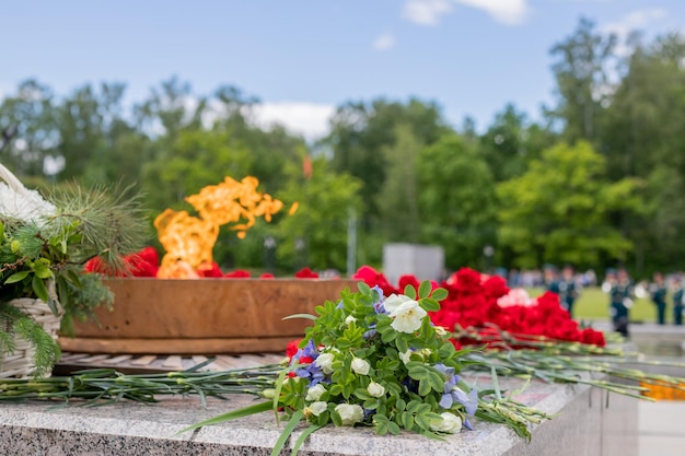 Zdjęcie wieczny płomień pomnika wojny symbol pamięci narodu o poległych bohaterach 9 maja dzień zwycięstwa selektywne skupienie kwiaty pod pomnikiem grobu nieznanego żołnierza