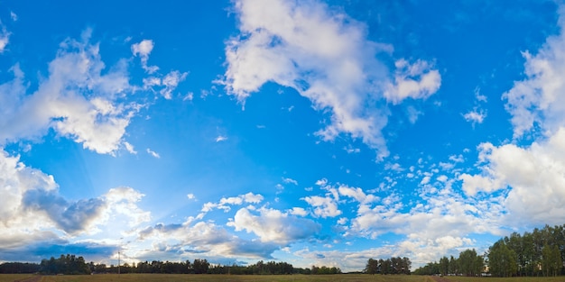 Wieczorna panorama błękitnego nieba z chmurami nad równiną i obóz w lesie. Siedem zdjęć ściegu.