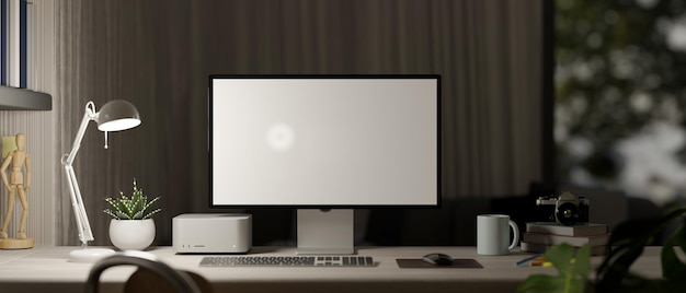 Wieczorne miejsce do pracy w domowym biurze z lampą stołową do komputera i akcesoriami na stole