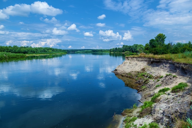 Wiejski krajobraz z pięknym zachodem słońca i chmurami nad rzeką