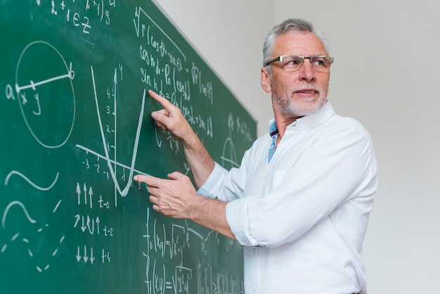 Zdjęcie wieku nauczyciel matematyki wyjaśniający funkcję w klasie