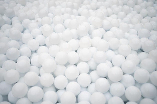 Wiele białych plastikowych piłek do suchego basenu