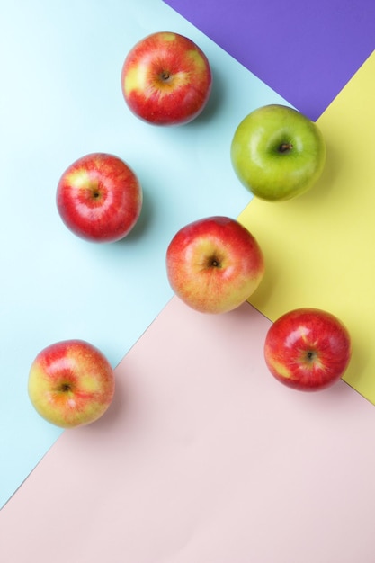 Wiele jabłek na kolorowym tle Czerwone i zielone jabłka rozrzucone na kolorowej powierzchni Świeże owoce dla zdrowej diety Widok z góry
