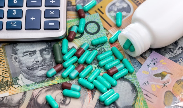 Zdjęcie wiele kolorowych leków i pigułek na australijskich banknotach dolarowych koncepcja medycyny