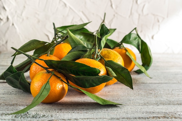 Wiele pomarańczowych mandarynek z zielonymi liśćmi na białym tle
