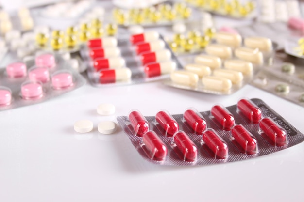 Wiele różnych i wielokolorowych tabletek na białym stole Krople do nosa i instrukcje Opieka zdrowotna