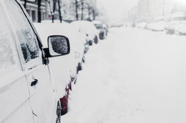 Wiele samochodów na zimowej drodze lub na parkingu Śnieżne miasto Opady śniegu zimą Korki i złe warunki pogodowe Krajobraz miejski Samochody utknęły w śniegu