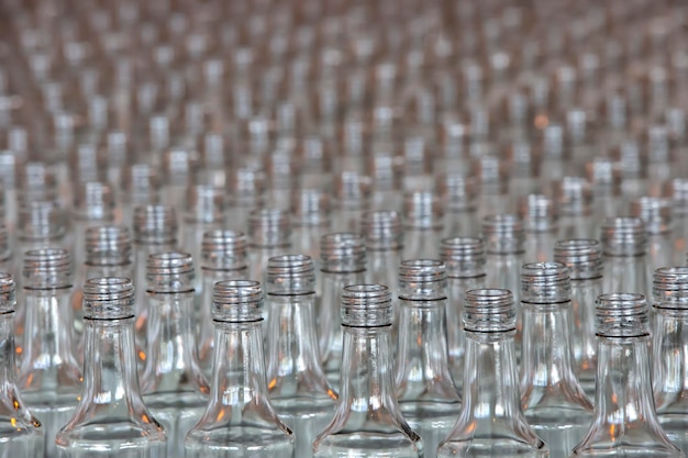 Wiele szklanych butelek na fabrycznym przenośniku