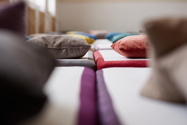 Wiele wielokolorowych łóżek z poduszkami i pościelą we wnętrzu siłowni
