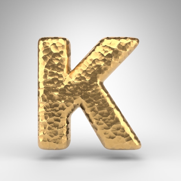 Wielka litera K na białym tle. Młotkowany mosiądz 3D renderowana czcionka z błyszczącą metaliczną teksturą.