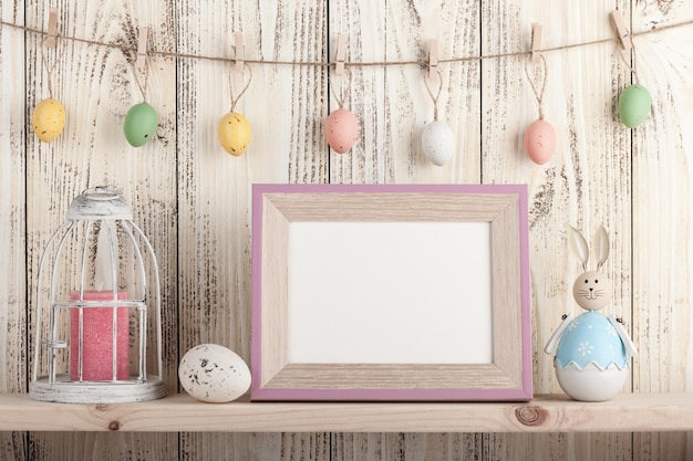 Wielkanocna dekoracja z pustą drewnianą ramą na półce