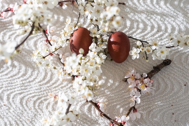 Wielkanocna kompozycja dekoracyjna z malowanymi jajkami, kwitnącymi gałęziami.