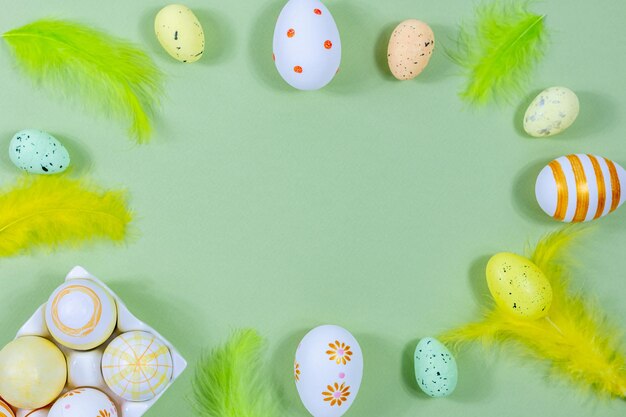 Wielkanocna ramka z kolorowymi jajkami i piórami