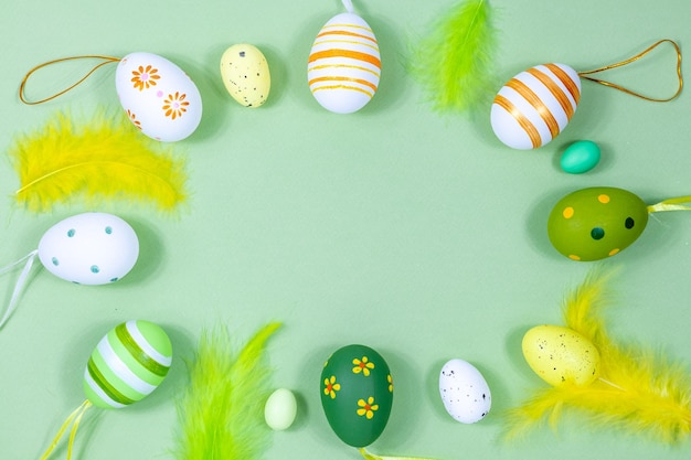 Wielkanocna ramka z kolorowymi jajkami i piórami