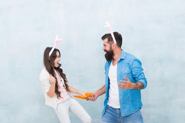 Wielkanocna zabawa i szczęście Ojciec i córka bawią się marchewką Wiosenne wakacje Wspólne świętowanie Wielkanocy Gotowanie wielkanocnego jedzenia Zdrowe nawyki Uszy króliczka dla dziewczynki i taty Szczęśliwa rodzina nosi uszy królika