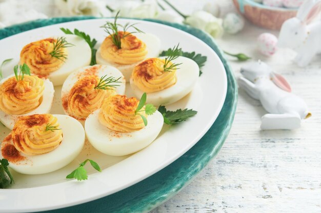 Wielkanocne jajka wypełnione Tradycyjny wielkanocny brunch lub kolacja z jajkami wypełnionymi z papryką, ciastkami z marchewkami i ciastkami czekoladowymi z glazowanymi jajkami.