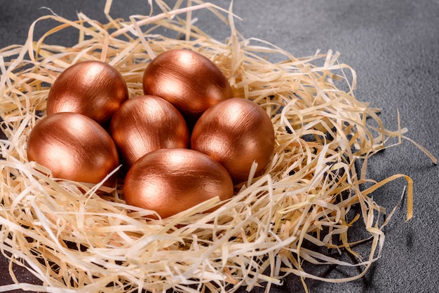 Wielkanocne złote jajka w gnieździe, przygotowanie do wakacji. Złote jaja w gnieździe