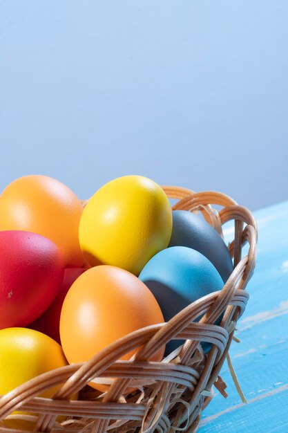 Wielkanocny kosz ze słomianymi i kolorowymi jajkami
