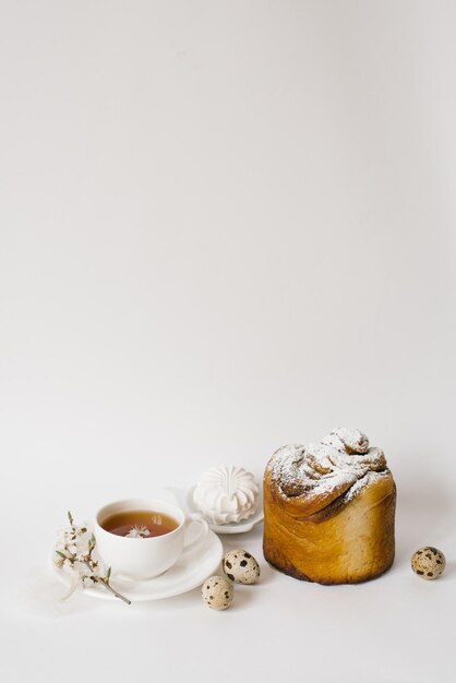 Wielkanocny słodki chleb ciasto i jajka z białymi kwiatami jabłka filiżanka herbaty Świąteczna koncepcja śniadania