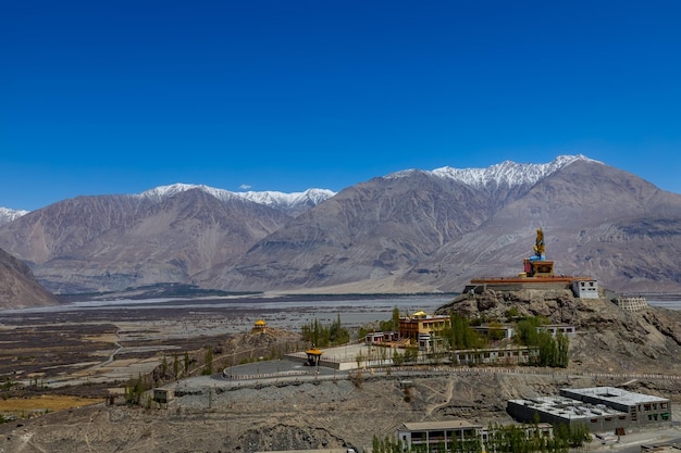 Wielki siedzący posąg Buddy w klasztorze Diskit z pasmem Himalajów z tyłu LadakhIndia