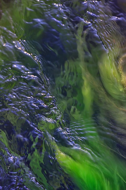 wielobarwna faktura tafli strumienia wody, czysta woda, kolorowe kamienie na dnie rzeki
