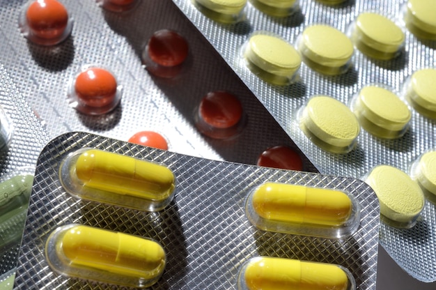 Wielobarwne tabletki w foliowych blistrach leżą