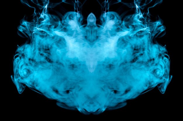 Zdjęcie wielobarwny wzór fioletowego i niebieskiego dymu o mistycznym kształcie w postaci głowy ducha lub dziwnego stworzenia na czarnym izolowanym tle abstrakcyjny wzór fal i pary